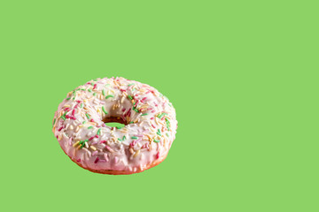Fresh frosting glazed donut on green background.