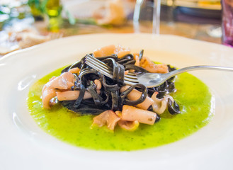 squid ink spaghetti with squid on a bed of spinach cream