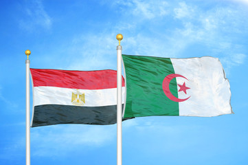 Egypt and Algeria  two flags on flagpoles and blue cloudy sky