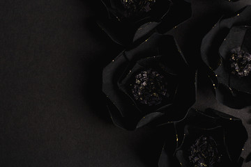 black background with a beautiful gold glittering flowers made of paper