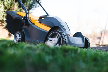 Electric lawn mower on a lawn at the garden. Gardening concept