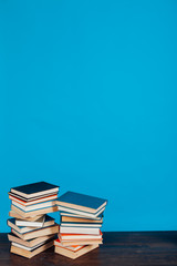 many stacks of educational books for learning preparation for college exams on a blue background