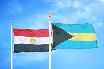 Egypt and Bahamas  two flags on flagpoles and blue cloudy sky