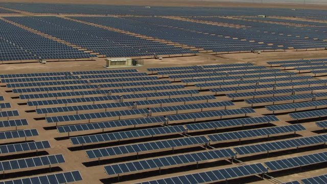 Flying over hundreds of solar energy panels at the Atacama Desert in Chile. Massive Photovoltaic Plant in the middle of the desert, green sustainable energy concept, aerial view.