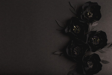 black background with a beautiful gold glittering flowers made of paper