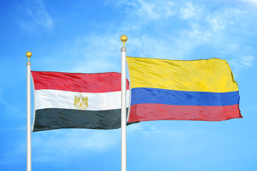 Egypt and Colombia two flags on flagpoles and blue cloudy sky