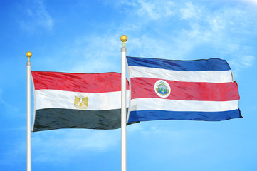 Egypt and Costa Rica two flags on flagpoles and blue cloudy sky