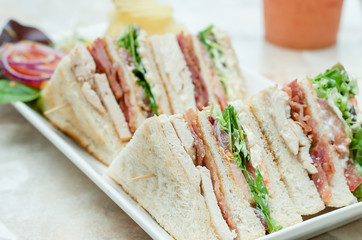 A selection of various sandwiches and fillings, garnished with crisps and salad.