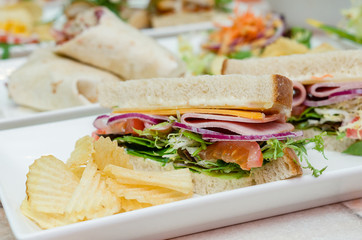 A selection of various sandwiches and fillings, garnished with crisps and salad.