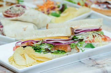 A selection of various sandwiches and fillings, garnished with crisps and salad.