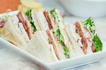 A selection of various sandwiches and fillings, garnished with crisps and salad.