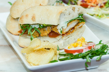 A selection of various sandwiches and fillings, garnished with crisps and salad.