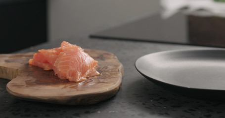 slices of salted trout with knife on olive wood board