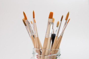 Brushes for painting with watercolor and acrylic, in a glass pot, white background