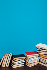 many stacks of educational books for learning preparation for college exams on a blue background