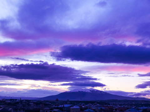 storm clouds over the city, a fairy-tale sunset over the mountains, dramatic sky at sunset, time lapse clouds