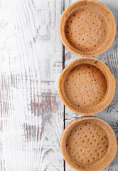 Empty baked shortbread tartlets ready to be filled in with a dessert. Base for mini tarts