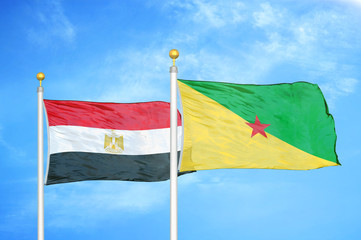 Egypt and French Guiana two flags on flagpoles and blue cloudy sky