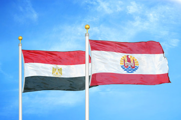 Egypt and French Polynesia two flags on flagpoles and blue cloudy sky
