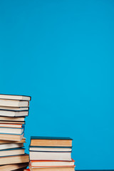 many stacks of educational books for learning preparation for college exams on a blue background