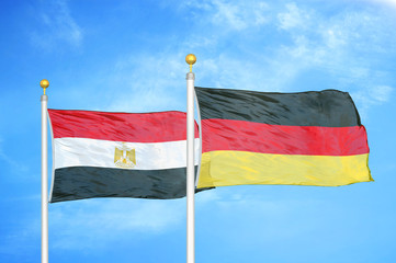 Egypt and Germany two flags on flagpoles and blue cloudy sky