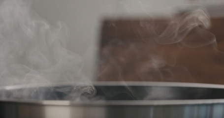 steam rising from pan while cooking food closeup
