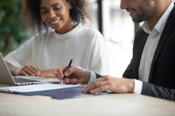 Close up happy businessman signing partnership agreement. Focused male on putting signature,...