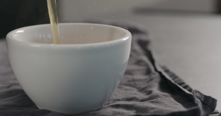 pour black tea in white cup closeup with copy space