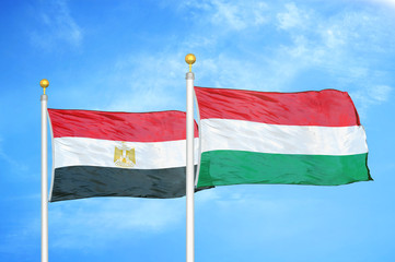 Egypt and Hungary two flags on flagpoles and blue cloudy sky