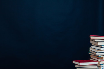 many stacks of educational books for learning preparation for college exams on a black background