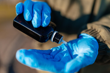 Antiseptic in a bottle on medical gloves