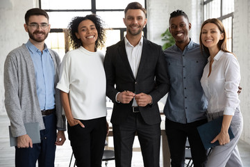 Portrait of standing in row smiling diverse team looking at camera. Happy multiethnic corporate staff, young specialists, company representatives, bank workers photo shoot, HR agency recruitments. - Powered by Adobe