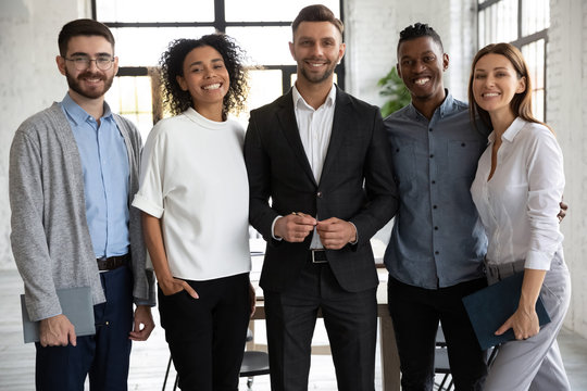 Portrait of standing in row smiling diverse team looking at camera. Happy multiethnic corporate staff, young specialists, company representatives, bank workers photo shoot, HR agency recruitments.