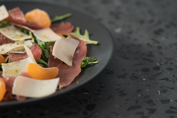 Salad with prosciutto, tangerines and vintage cheese with copy space