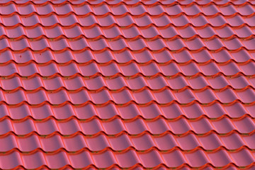 Roof of a house with modern red metal roof tiles