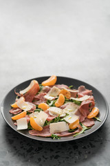 Salad with prosciutto, tangerines and vintage cheese with copy space