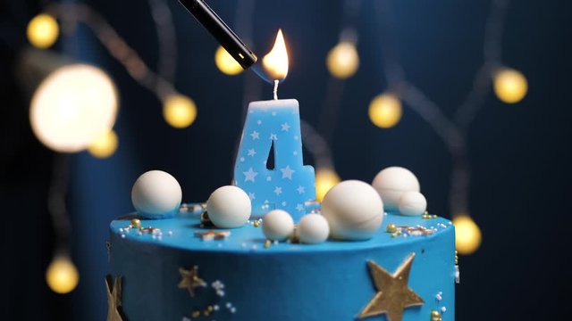 Birthday cake number 4 stars sky and moon concept, blue candle is fire by lighter and then blows out. Copy space on right side of screen if required. Close-up and slow motion