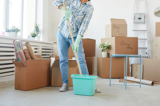 Low section portrait of happy young woman cleaning new house or apartment while moving in, copy space