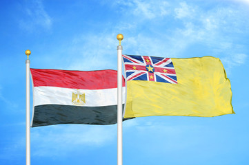 Egypt and Niue two flags on flagpoles and blue cloudy sky