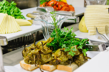 Roasted peppers garnished with parsley and rosemary at the buffet counter of a restaurant