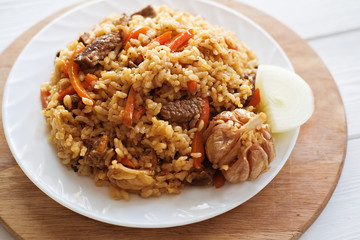 pilaf- spicy delicious traditional asian dish made of rice, vegetables and meat in a plate. Top view. eastern cuisine
