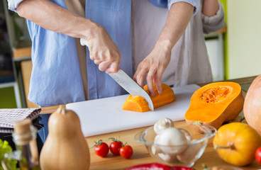 Couple cooking dinner from fresh tomatoes and pumpkin