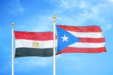 Egypt and Puerto Rico two flags on flagpoles and blue cloudy sky