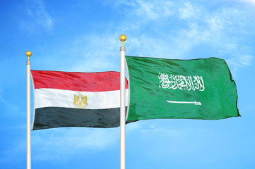 Egypt and Saudi Arabia two flags on flagpoles and blue cloudy sky