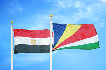 Egypt and Seychelles two flags on flagpoles and blue cloudy sky