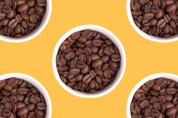 Five cups with coffee grains on a yellow background.
