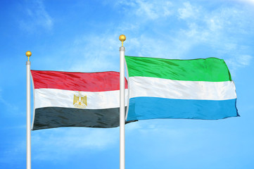 Egypt and Sierra Leone two flags on flagpoles and blue cloudy sky