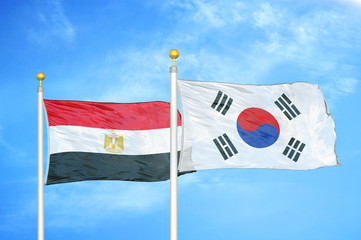 Egypt and South Korea two flags on flagpoles and blue cloudy sky