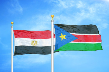 Egypt and South Sudan two flags on flagpoles and blue cloudy sky