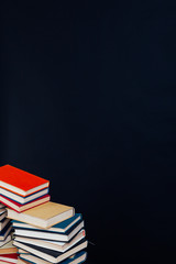 many stacks of educational books for learning preparation for college exams on a black background